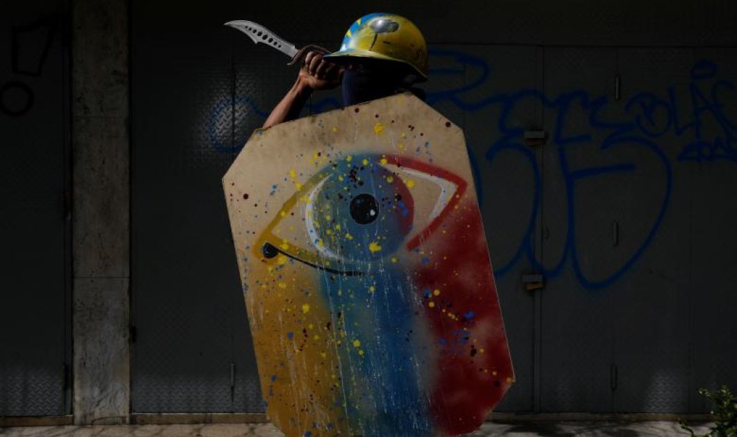 Διαδηλωτής στην Βενεζουέλα κρατά μια ευφάνταστη ασπίδα - Picture: REUTERS / Carlos Garcia Rawlins