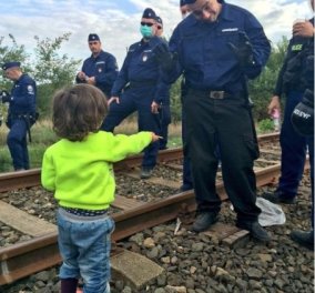 Προσφυγόπουλο προσφέρει ένα μπισκότο σε αστυνομικό στα σύνορα στην Ουγγαρία  - Κυρίως Φωτογραφία - Gallery - Video