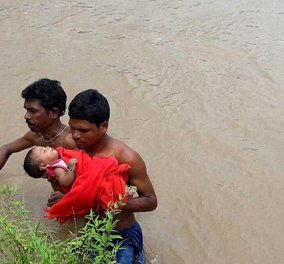 Συγκινούν οι φωτογραφίες με τον πατέρα που κουβαλάει το άρρωστο μωρό του μέσα στις πλημμύρες για 2 ώρες