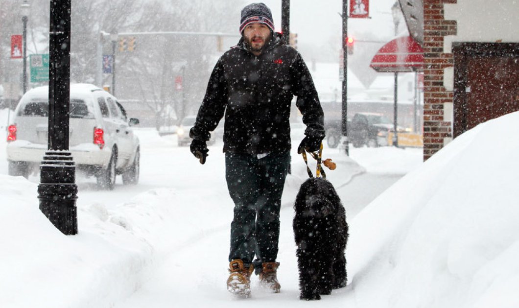10/02/2015: Στο έλεος του χιονιά και οι ΗΠΑ - Ένα απίθανο στιγμιότυπο με έναν νεαρό να βολτάρει με το σκυλάκι του «τουρτουρίζοντας» από το κρύο! Φωτό: Bill Sikes/AP
