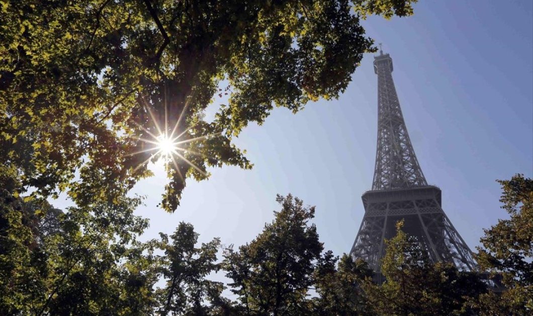 4/10/2015 - Ο ήλιος λάμπει μέσα από τα φύλλα των δέντρων κοντά στον Πύργο του Άιφελ μία ζεστή φθινοπωρινή ημέρα στο Παρίσι - REUTERS / REGIS DUVIGNAU