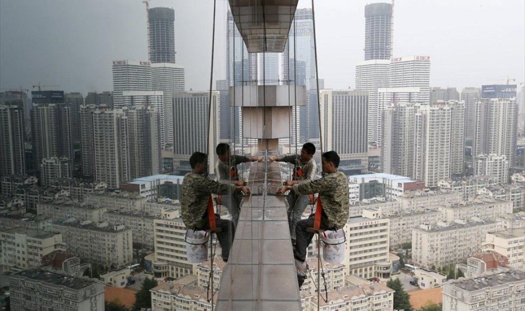 12/10/2015 - 2 ή 4 άντρες ριψοκίνδυνοι άντρες καθαρίζουν τα παράθυρα κτηρίου 30 ορόφων στη Κίνα; REUTERS / CHINA STRINGER NETWORK